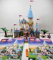 Front view of assembled Cinderella's Romantic Castle with two instruction booklets and a small orange brick separator on display.