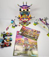 Complete LEGO Friends 41352 The Big Race Day set fully assembled with instruction manuals laid out, showing building, go-karts, drone, and race arch.