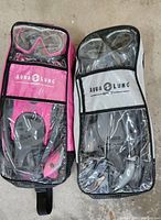 Photo showing both Aqua Lung Sport snorkel sets in carry bags, pink on left and grey on right.