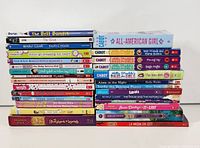 Full stacked view of 26 tween fiction books including Baby-Sitters Club and Puppy Place series.