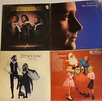 Four vintage LP vinyl records showing the front covers of Bee Gees, Phil Collins, Fleetwood Mac, and Christmas Party albums.