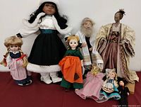 Group photo showing all 8 vintage dolls arranged together, featuring variety of styles and costumes.