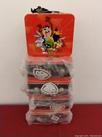 Stack of five Looney Tunes lunch boxes in orange packaging, wrapped in original plastic with visible tags.