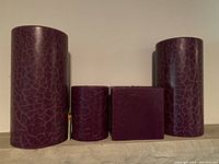 Four purple candles in cracked pattern finish, arranged side by side showing size and shape differences