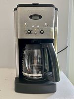 Front view of Cuisinart coffee maker powered on showing digital display and control panel.