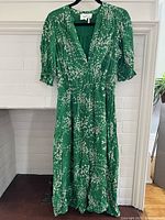 Front view of green ba&sh dress, showing floral print, length, sleeves, and overall style.