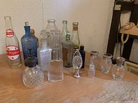 Group view of all bottles on wood table, showing variety of sizes and shapes