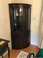 Front view of cabinet closed showing curved glass upper doors, drawer and lower doors