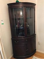 Front view showing overall design with upper glass doors and lower wood storage