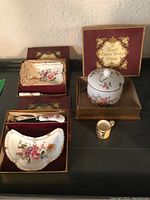 Full display of the Royal Crown Derby Derby Posies serving ware set showing small dishes, jam pot, miniature mug, and spreader in original boxes.