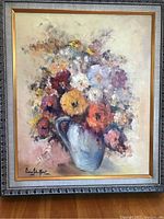Framed full view of the painting showing the floral arrangement and artist's signature on bottom left.