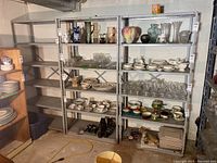 Full view of three steel shelving units, showing size and structure, empty except for unrelated items around.