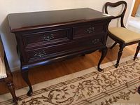 Front view of mahogany side table showing three drawers and bail pulls