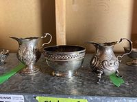Front view of two creamers and sugar bowl displaying overall appearance and included items