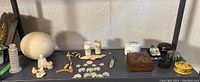 Overview of ostrich egg, trinket boxes and assorted trinkets on shelf