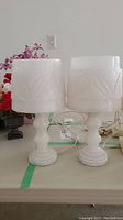 Pair of white marble lamps side by side on a table, showing overall height and shape.