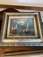 Full view of framed painting showing harbour scene with lighthouse and boats