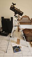 Full assembled telescope on tripod with mount, accessories and planisphere on floor