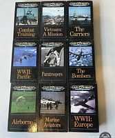 Photo of nine Air Combat VHS tapes arranged in three rows of three. Each VHS tape has a black case with distinct historical aviation themed titles and cover images.