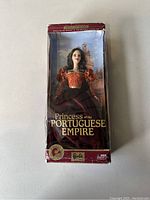 Photo of boxed Princess of the Portuguese Empire Barbie doll showing the doll in red and burgundy costume inside a worn box.