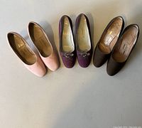 Three pairs of designer ladies high heel shoes shown from above in photo: purple, pink, and brown pairs, all size 5-1/2 B or 6 B