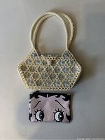 Photo showing two purses: a vintage beaded handbag with white and translucent beads and a Betty Boop zipper pouch with face print.