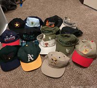 Full lot display of 13 baseball caps with various colors and embroidered logos.