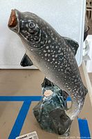 Front and side view of the ceramic fish decanter showing full shape, texture, and base with label.