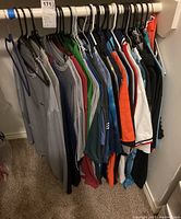 Full rack of assorted men's golf shirts and t-shirts, various colors and brands
