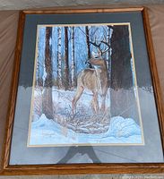 Framed print of deer in a snowy forest by Jorge Arrieta, signed and matted in a wooden frame.