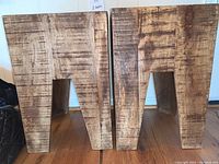 Front and side view of two rough hewn wood side tables showing their shape and texture