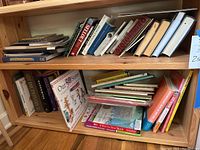 Photo showing two shelves with assorted books in hardback and softback formats, including children's books and reference volumes.
