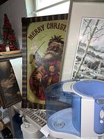 Photo of Kenmore humidifier next to framed vintage Christmas Santa picture and framed religious picture