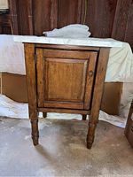 Front view of wood vanity cabinet with marble top and integrated sink