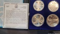 Display case open showing information card and all four silver coins