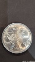 Reverse side of the coin showing world map and Montreal 1976 Olympic details with 10 Dollars value.