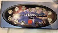 Flat presentation set showing all 14 Canadian millennium quarters in designated slots on holder with a map design background and title wording