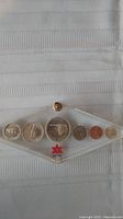 Full view of set of 6 Canadian coins from 1967, displayed in a transparent protective case bearing the 1967 centennial logo.