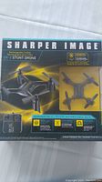 Front view of the packaged Sharper Image DX-2 Stunt Drone showing drone image, name, and features.