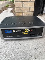 Rear of InFocus projector showing input ports including VGA, USB, S-Video, audio/video.