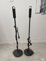 Pair of Steelcase Thread vertical freestanding power outlets side by side, showing full height and cord wrapped around poles.