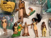 Top view of multiple Pocahontas themed figurines including loose and packaged items