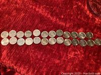 Two rows of Canadian pennies laid out on red velvet fabric, showing two complete sets spanning years 2000 through 2011 plus a 2012 penny.