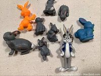 Photo of multiple vintage plastic rabbit figurines from McDonald's 1985 giveaway collection, various colors including gray, orange, blue