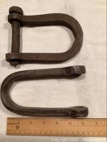 Top view of two antique tractor clevises with a ruler showing approximately 6 inches