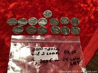 Top view of 14 Canadian nickels arranged in two rows, showing front and reverse sides with key coin details visible.