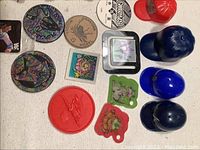 Top view showing wooden nickels, plastic collectible tokens, miniature baseball hats, and small square graphic patches.