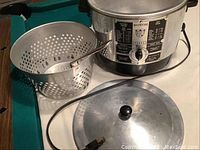 Front and side view of the Rotor cooker fryer casserole unit with attached basket, lid placed on top, and power cord visible on table.