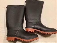 Side view of the black rubber boots showing the matte finish and height, size around mid-calf.