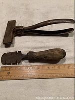 Photo of vintage canvas pliers and saw tooth setter alongside a ruler for size reference showing 8-inch and 6.5-inch measurements respectively.